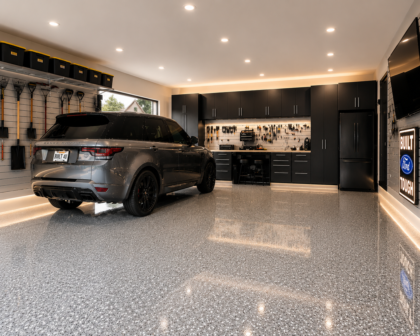 Finished residential garage with polyaspartic floor coating, accent lighting, dark cabinetry and Range Rover in Edmonton